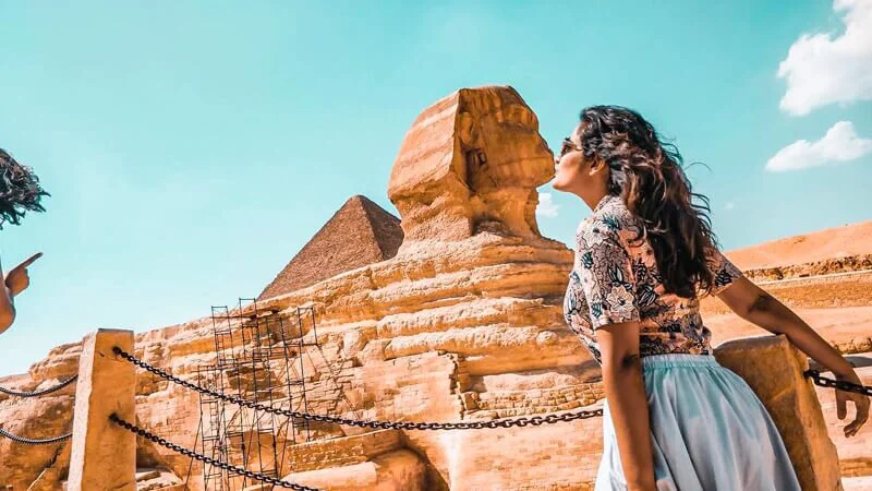 Top 10 Things to Do and See in Pyramids of Giza 29 a female tourist taking a beautiful picture with sphinx