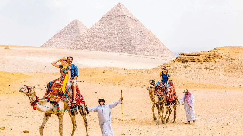 Top 10 Things to Do and See in Pyramids of Giza 24 tourists on camel rides in front of the giza pyramids
